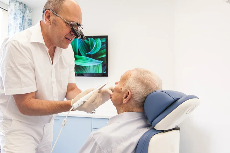 Zahnarzt erklärt Behandlung mithilfe der Nutzung einer Intraoral-Kamera